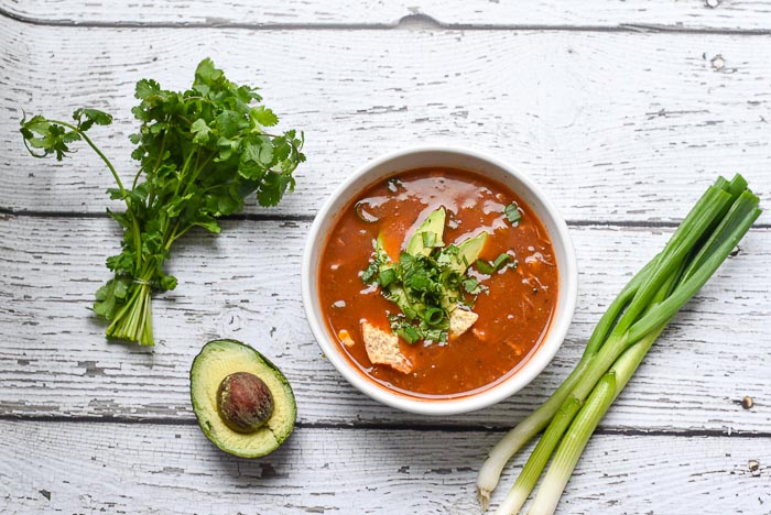 chicken tortilla soup with scallions, cilantro and avocado on a barn board background, Flower Patch Farmhouse