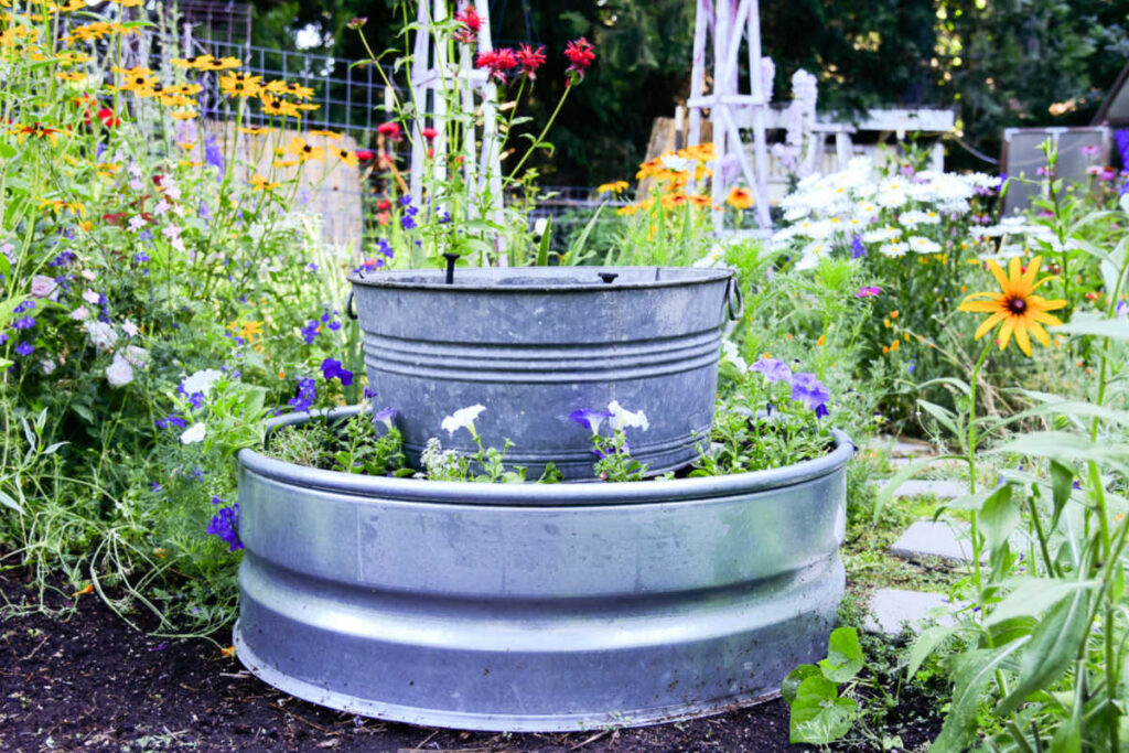 galvanized fire ring with tub fountain in center of garden