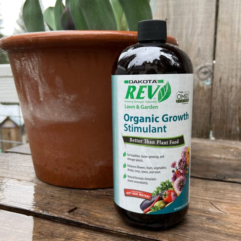bottle of Organic Rev with potted plant on potting bench