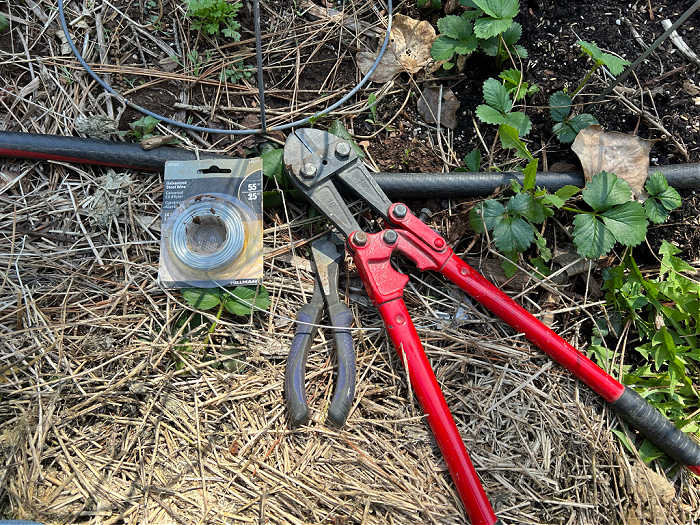 galvanized wire, wire cutters and bolt cutters lying by tomato cage