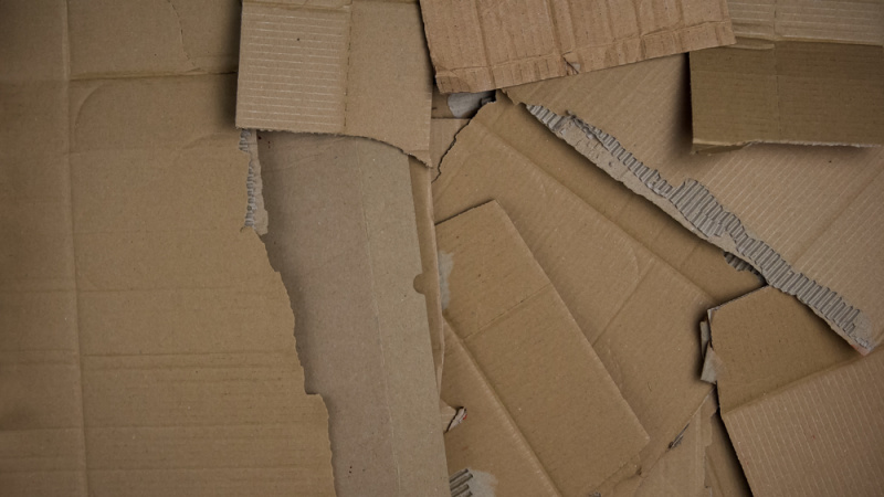 torn cardboard readied for laying in a garden bed as mulch