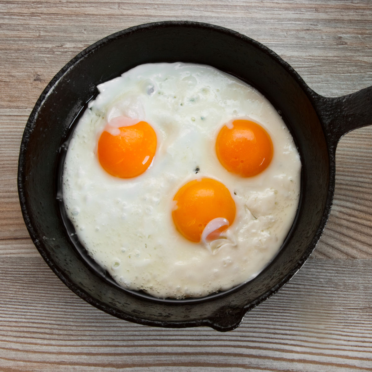 2 eggs with orange yolks in cast iron frying pan