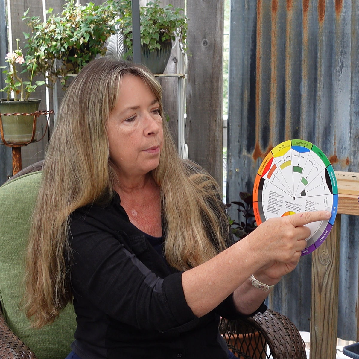 woman using a color wheel with plants in the background